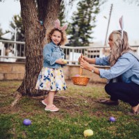 girl looking for eggs during easter egg hunt with grandmother - garden decoration stock pictures, royalty-free photos & images