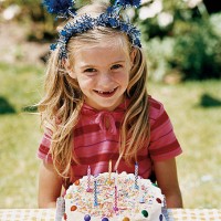 girl sitting at a table with her birthday cake - garden decoration stock pictures, royalty-free photos & images