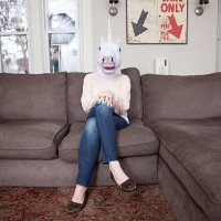 girl sitting on sofa wearing unicorn head mask - home decoration stock pictures, royalty-free photos & images