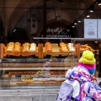 Girl walks past a shop with fresh doughnuts on Fat Thursday , February 8, 2024 in central Krakow, Poland. Fat Thursday is a Polish tradition, with...