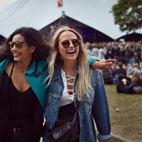 girlfriends laughing together at outside festival - concert stock pictures, royalty-free photos & images