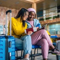 girlfriends using mobile phone at the airport - travel stock pictures, royalty-free photos & images