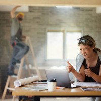 glücklicher innenarchitekt, der einen videoanruf über den laptop bei der renovierung des hauses führt. - home decoration stock-fotos und bilder