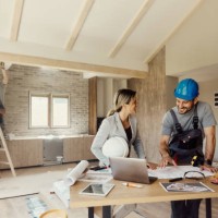 glücklicher inspektor und handarbeiter, der während des renovierungsprozesses über wohnpläne spricht. - home decoration stock-fotos und bilder