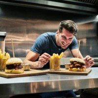 glimlachend chef-kok te kijken naar voedsel geserveerd op counter - junk food stockfoto's en -beelden