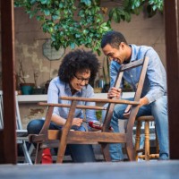 glimlachend jong koppel werken samen om te herstellen van een stoel - home decoration stockfoto's en -beelden