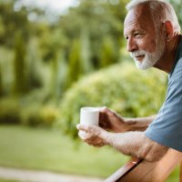 glimlachend volwassen man genieten in de ochtend koffie op een terras. - coffee stockfoto's en -beelden