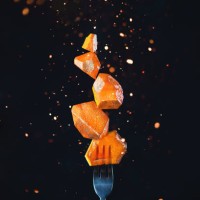 golden marmalade block on a fork with sparks and flares. action food photography on a dark background with copy space. gourmet dessert concept. - food stock pictures, royalty-free photos & images