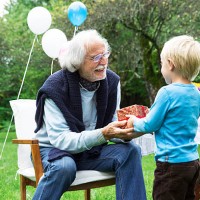 grandfather receiving gifts on birthday party in garden - garden decoration stock pictures, royalty-free photos & images