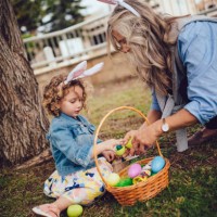 grandmother and little granddaughter celebrating easter with easter egg hunt - garden decoration stock pictures, royalty-free photos & images