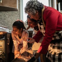 grandmother, mother and daughter looking at food in the oven at home - food stock pictures, royalty-free photos & images