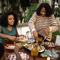 grandmother serving food to family during christmas lunch outdoors at home - garden decoration stock pictures, royalty-free photos & images