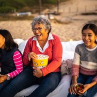 grandmother with grandchildren watching a movie at the outdoors cinema - concert stock pictures, royalty-free photos & images