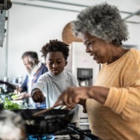 grandson helping his grandmother cooking at home - food stock pictures, royalty-free photos & images