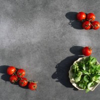 gray background with cherry tomatoes and spinach. kitchen. recipe. cooking. background for any food. - food stock pictures, royalty-free photos & images