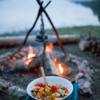 great looking and delicious food cooked at the campsite waits to be eaten next to the campfire - food stock pictures, royalty-free photos & images