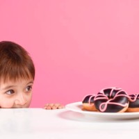 greedy boy looking at doughnuts - junk food stock pictures, royalty-free photos & images