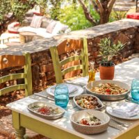 greek dinner table with food and plates under olive trees with cretan delicacies - food stock pictures, royalty-free photos & images