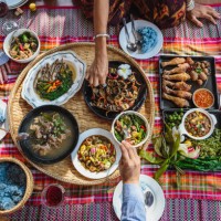 groep aziatische mensenfamilie geniet van het vieren van thais voedseldiner terwijl het zitten op mat thuis, noordoost thailand (issan) gezond traditioneel thais voedselconcept, hoogste mening - food stockfoto's en -beelden