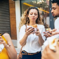 group of friends eating burgers - junk food stock pictures, royalty-free photos & images