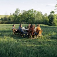 group of friends enjoying dinner in rustic field - food stock pictures, royalty-free photos & images