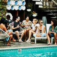 group of friends in discussion during party by pool hotel - fashion stock pictures, royalty-free photos & images