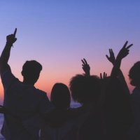 group of people partying on the beach at sunset or sunrise. - concert stock pictures, royalty-free photos & images