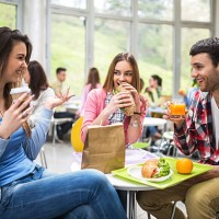group of students communicating during lunch in cafeteria. - food stock pictures, royalty-free photos & images