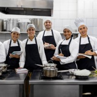 group of students smiling in a cooking class - food stock pictures, royalty-free photos & images