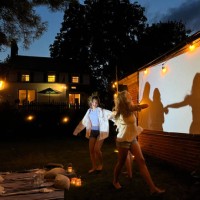 group of teenagers dancing in front of a glowing screen for outdoor movies - garden decoration photos et images de collection