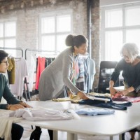 group of three people working in a clothing boutique - fashion stock pictures, royalty-free photos & images
