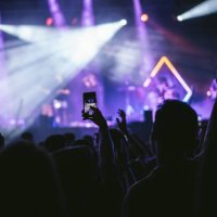 group of unrecognizable people enjoying a music concert while one of them takes a picture with his cell phone. - concert stock pictures, royalty-free photos & images
