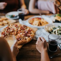 group of young asian man and woman having fun and enjoying food and drinks together during party - food stock pictures, royalty-free photos & images