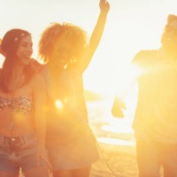 gruppe von freunden tanzen und feiern am strand bei sonnenaufgang / sonnenuntergang. - concert stock-fotos und bilder