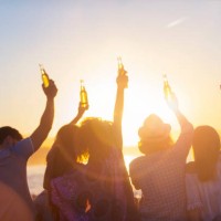 gruppe von jungen leuten, die bei sonnenuntergang am strand feiern. - concert stock-fotos und bilder