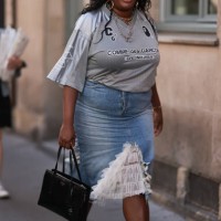 Guest is seen outside The Row show wearing golden earrings and necklaces oversized grey sports Comme des Garcons t-shirt with denim pencil skirt with...