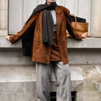 Guest is seen wearing a beige jacket, beige skirt, gray pants and brown scarf outside the Uma Wang show during Womenswear Spring/Summer 2025 as part...