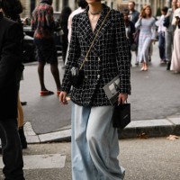 Guest is seen wearing a black and white tweed Chanel jacket, black and gold chain bag, light blue oversized jeans and black sunglasses outside the...