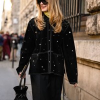 Guest is seen wearing a black embellished coat, black skirt, black and jeweled bag with black sunglasses outside the Hermes show during the...
