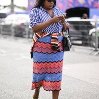 Guest is seen wearing a blue and white stripe shirt, red and blue skirt and lime green shoes with black sunglasses and a black bag outside the Dior...