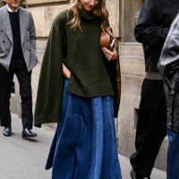 Guest is seen wearing a green sweater, denim skirt, brown bag and black shoes outside the Gabriela Hearst show during Womenswear Spring/Summer 2025...