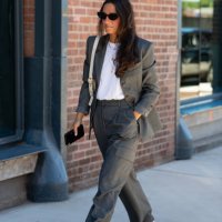 Guest is seen wearing a grey blazer, white top, grey pant, red shoes, black sunglasses and cream bag outside the Ulla Johnson show during New York...