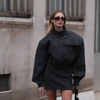 Guest is seen wearing a grey bomber jacket, matching skirt, black high boots, sunglasses, black handbag with silver details outside Victoria Tomas,...