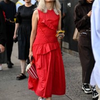 Guest is seen wearing a red dress and white Adidas sneakers with a popcorn bag outside the 3.1 Phillip Lim show during NYFW S/S 2024 on September 10,...