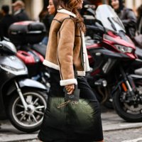 Guest is seen wearing a tan and faux fur jacket, black skirt and Isabel Marant green and black bag outside the Isabel Marant show during Womenswear...