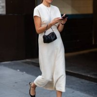 Guest is seen wearing a white dress, black shoes, black sunglasses and carrying a black bag outside the Patbo show during New York Fashion Week on...