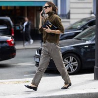 Guest is seen wearing black leather ballerinas, grey trousers, a kaki long sleeved sweater, a black leather bag and black sunglasses outside Chloe...