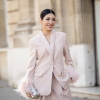 Guest is seen wearing light pink powder color suit with feather sleeves outside the Nina Ricci show during Paris Fashion Week - Womenswear Fall...