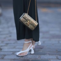 Guest seen wearing a grey long skirt, brown fur jacket, white heels, golden leo printed Celine handbag outside Stella McCartney show, during the...