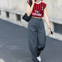 Guest, wearing an AC Milan shirt and grey pants, poses ahead of the Prada fashion show during the Milan Fashion Week - Spring / Summer 2022 on...